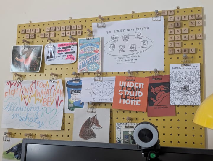 Olu's pegboard with various colourful notes on it including a drawing of a fox and some slogans spelt out in scrabble tiles